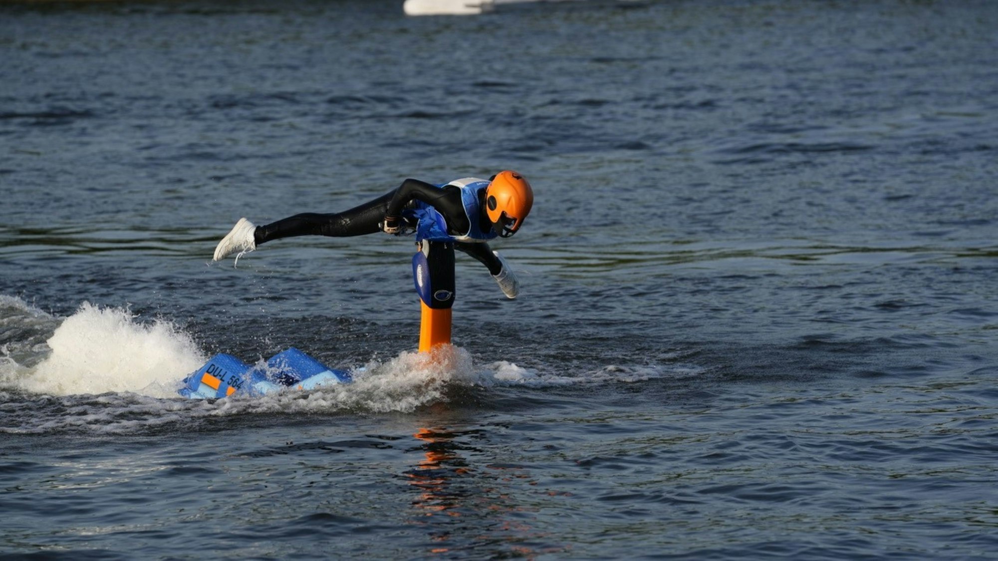Eine junge Frau macht Kunststücke auf einem Jetski.