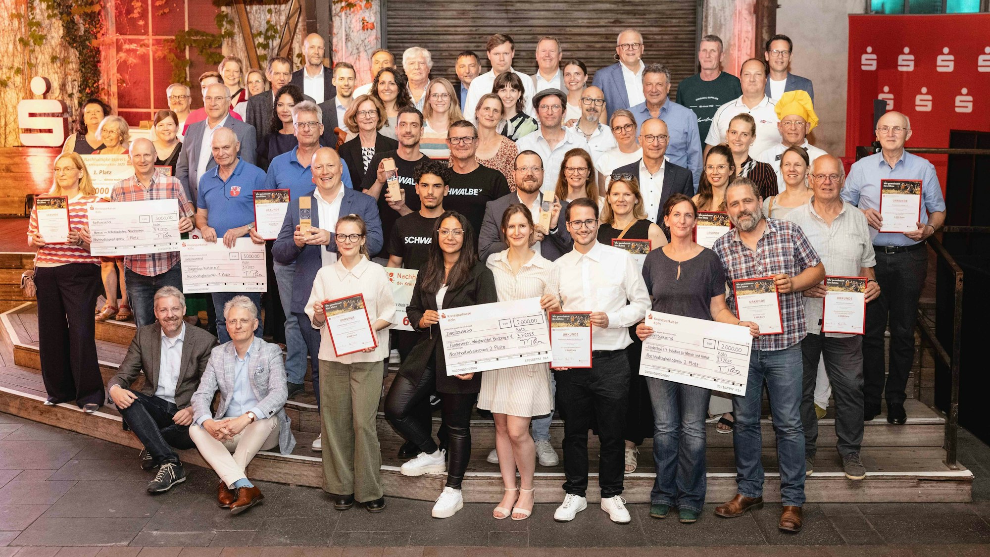 Die Sieger des Nachhaltigkeitspreis halten ihre Prämien in der Hand.