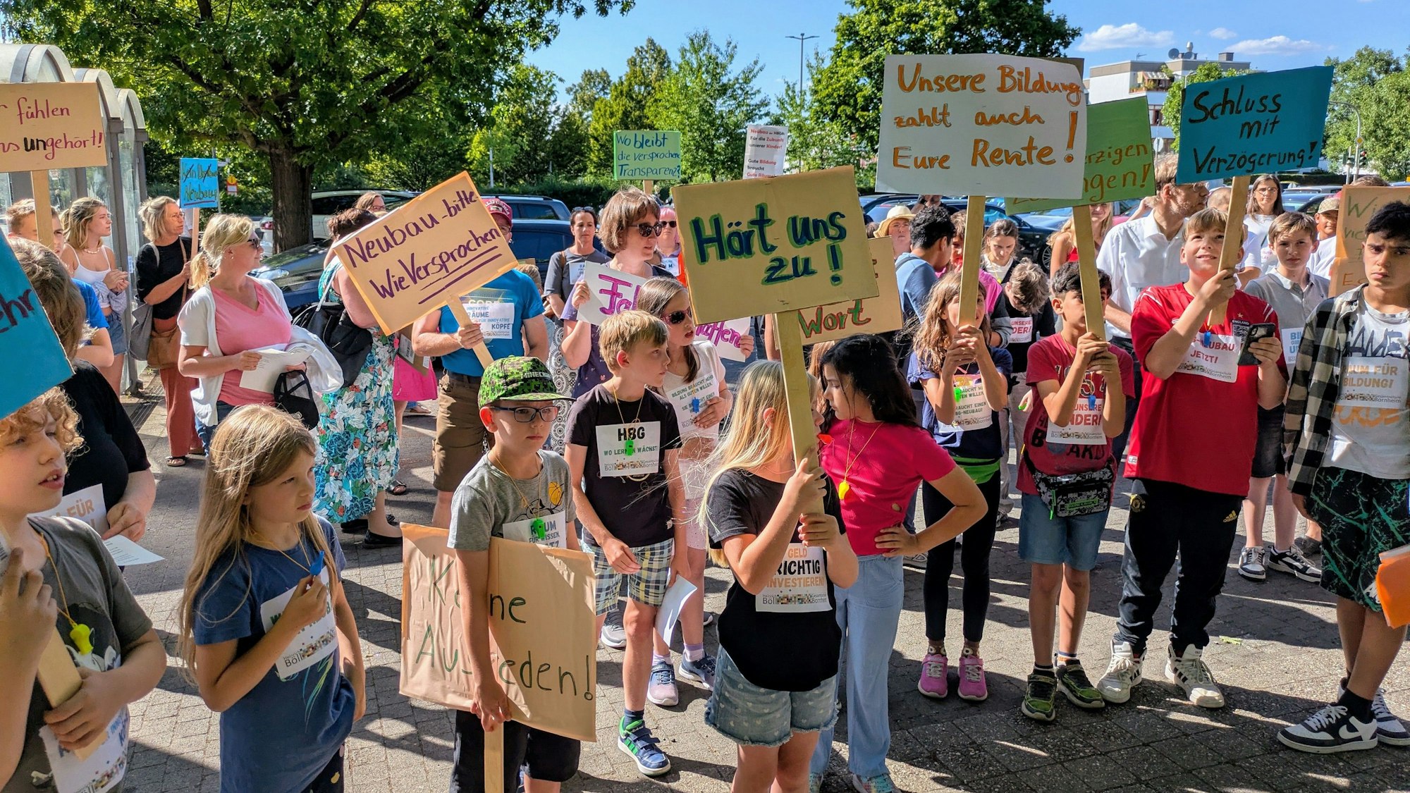 Schüler und Eltern der Heinrich-Böll-Gesamtschule und der Martinus-Schule stehen mit Plakaten vor dem Rathaus in Bornheim.
