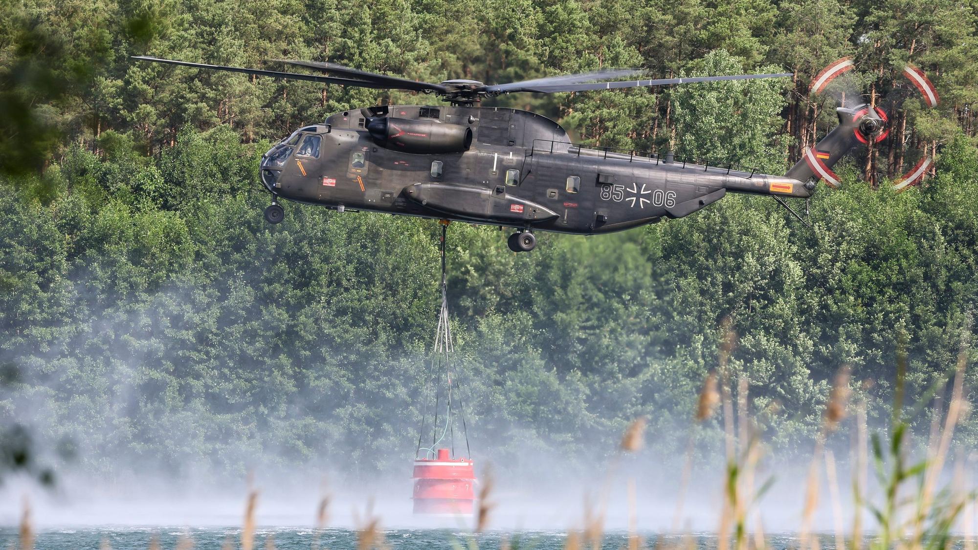 Ein Bundeswehrhubschrauber vom Typ Bell CH-53 holt Löschwasser zur Waldbrandbekämpfung aus dem Kiebitzer Baggerteich. (Symbolbild)