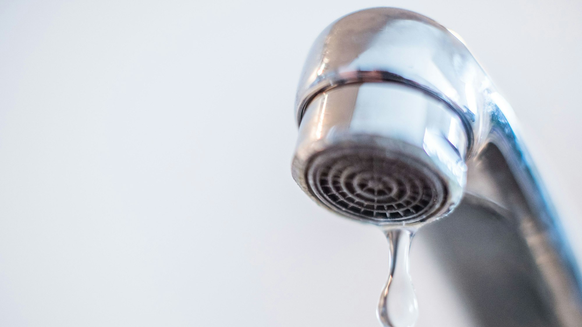 Das Bild zeigt einen Wasserhahn, aus dem Wasser tropft.