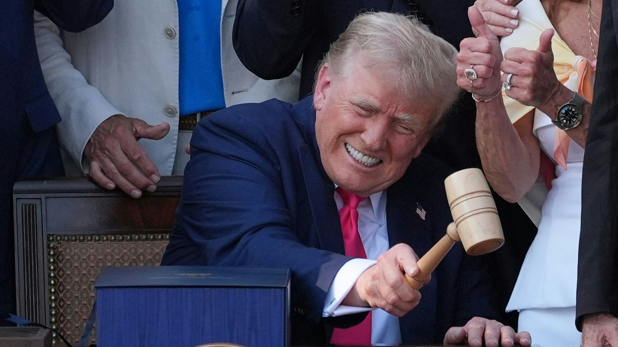 US-Präsident Donald Trump schlägt mit dem Hammer nachdem er sein Gesetz über Steuererleichterungen und Ausgabenkürzungen vor dem Weißen Haus unterzeichnet hat.