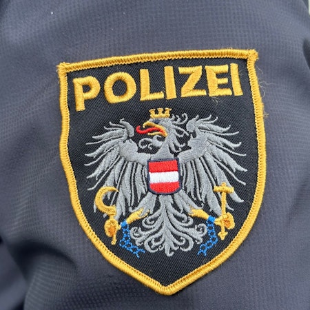 Das Emblem der österreichischen Polizei auf einer Uniform.