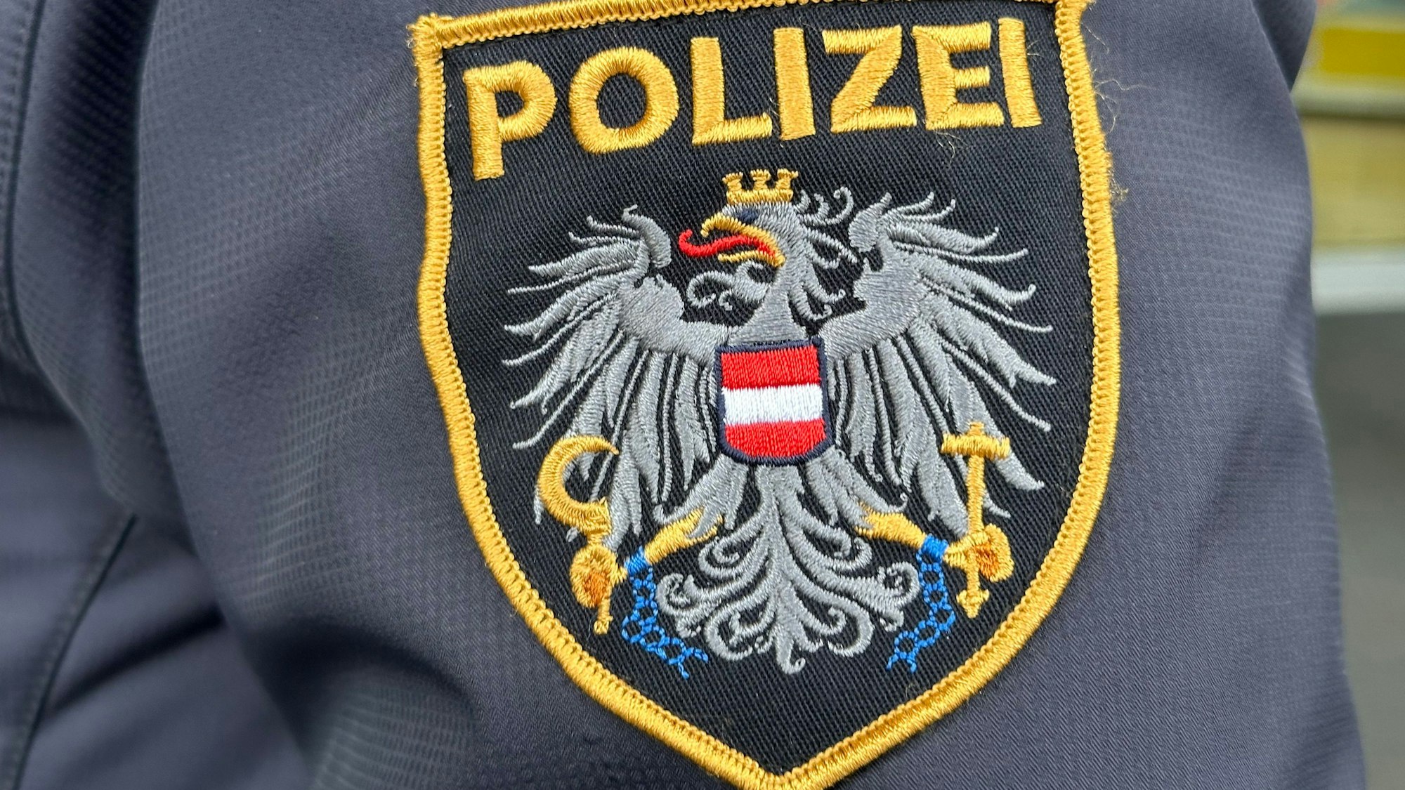 Das Emblem der österreichischen Polizei auf einer Uniform.
