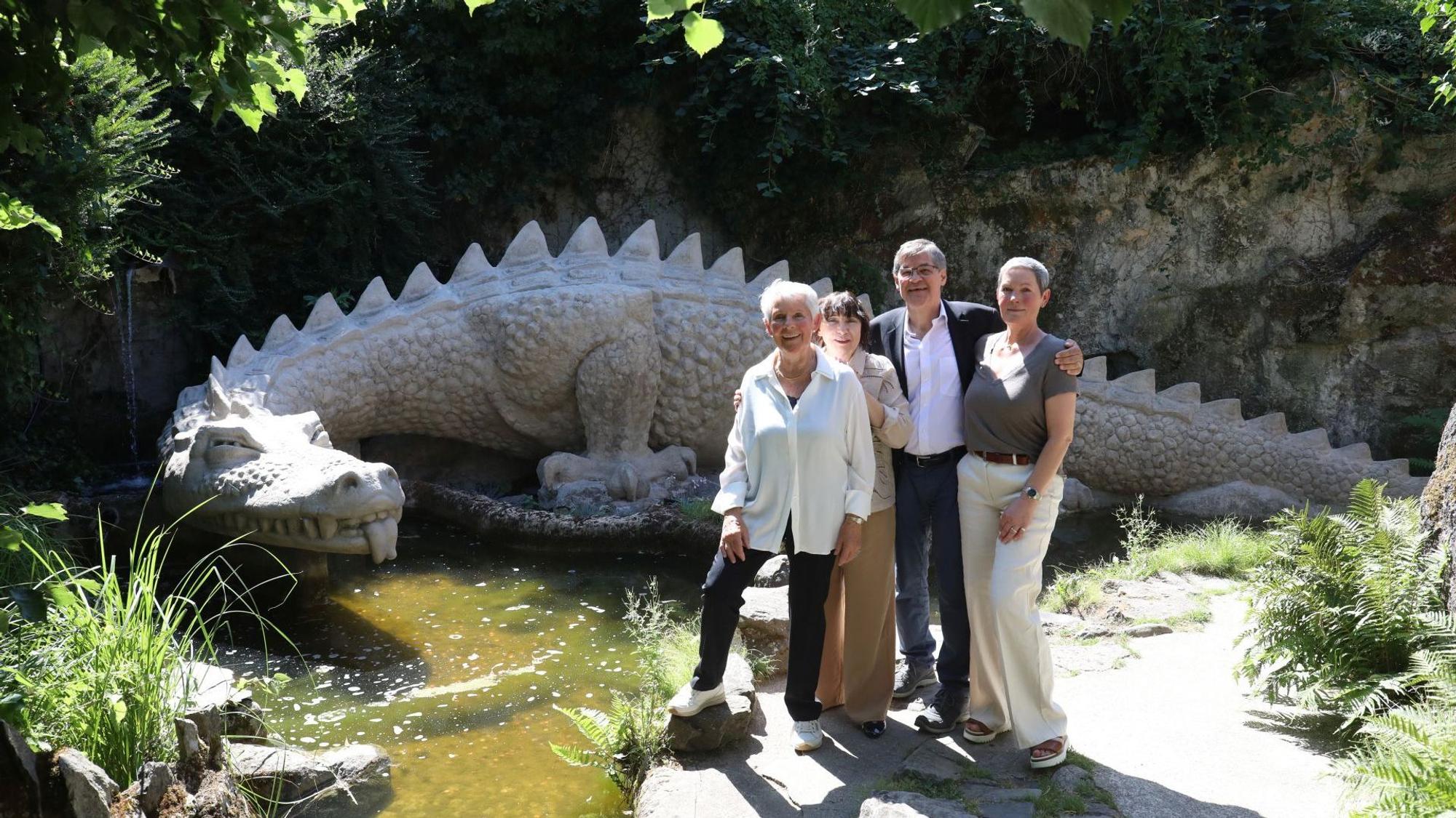 Vier Personen vor einer Steinskulptur, die einen Drachen darstellt.