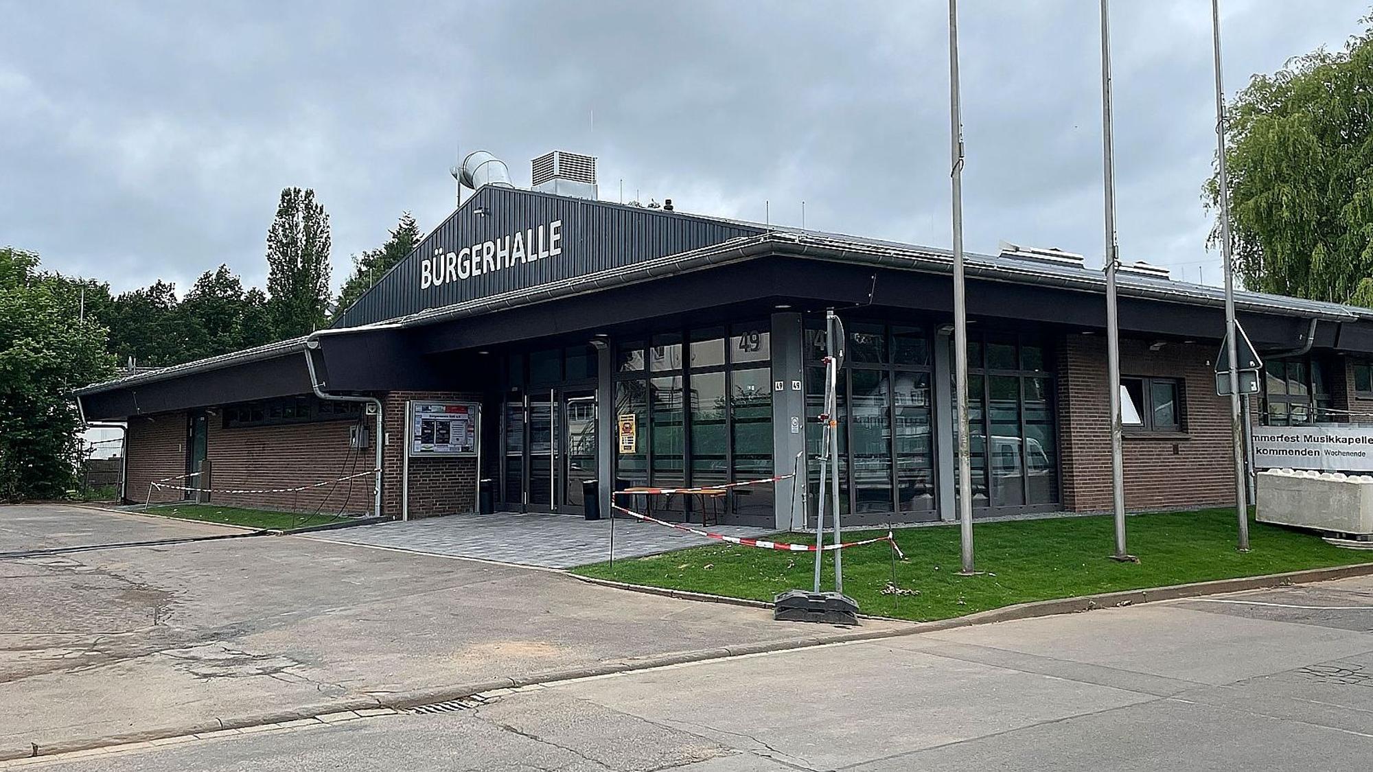 Das Bild zeigt ein Gebäude, auf dem in großen, weißen Buchstaben "Bürgerhalle" steht.