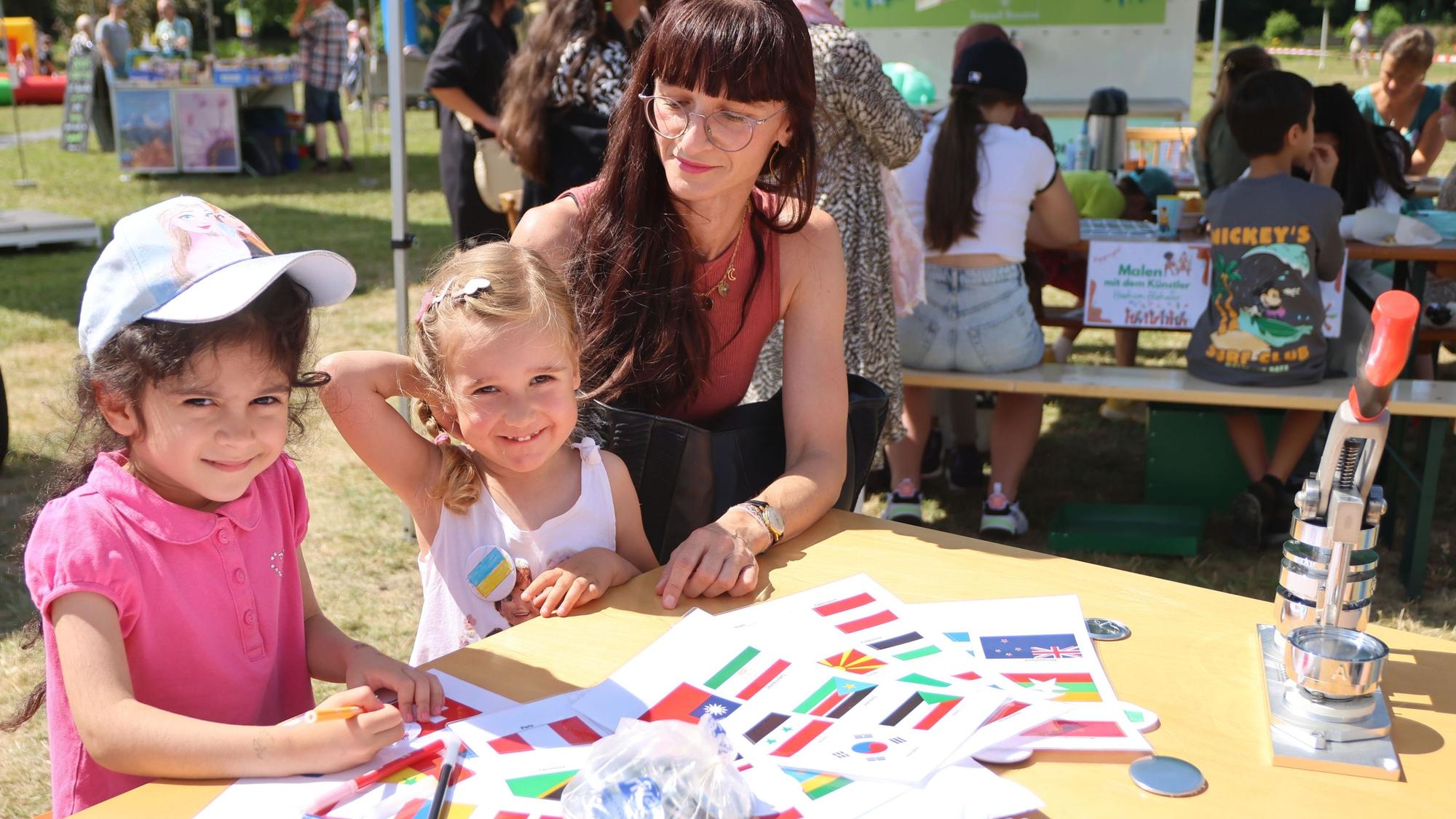 Spaß im Wiehlpark: Nelli (5) und Marie (3) malen mit ihrer Mutter Nataliya Fahnen nach. Das Begegnungsfest ist eines von dreien, das die Stadt am vergangenen Wochenende auf dem Freizeitgelände ausgerichtet hat.