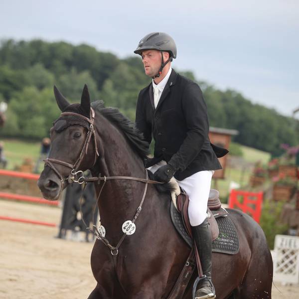 Zu sehen ist ein Springreiter auf seinem Pferd im Parcours.