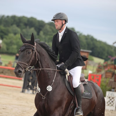 Zu sehen ist ein Springreiter auf seinem Pferd im Parcours.