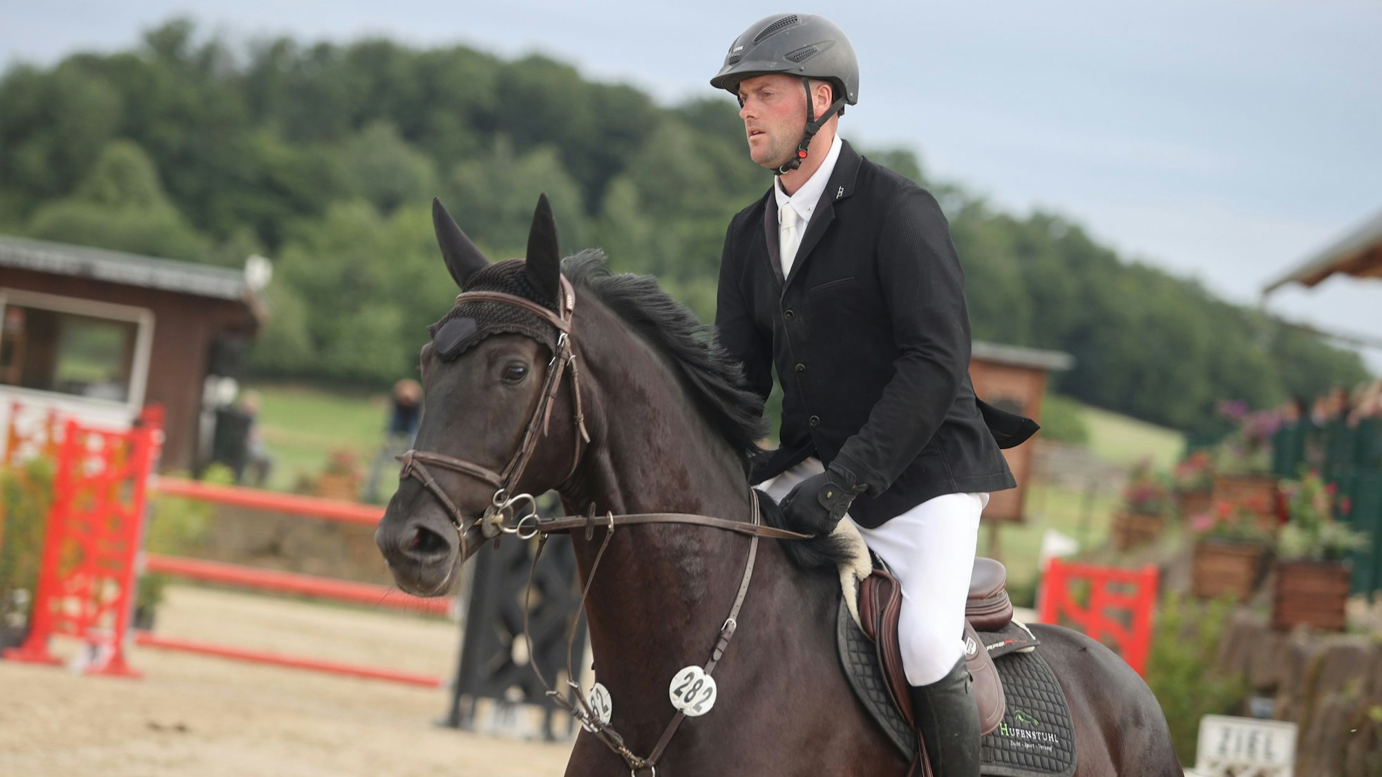 Zu sehen ist ein Springreiter auf seinem Pferd im Parcours.