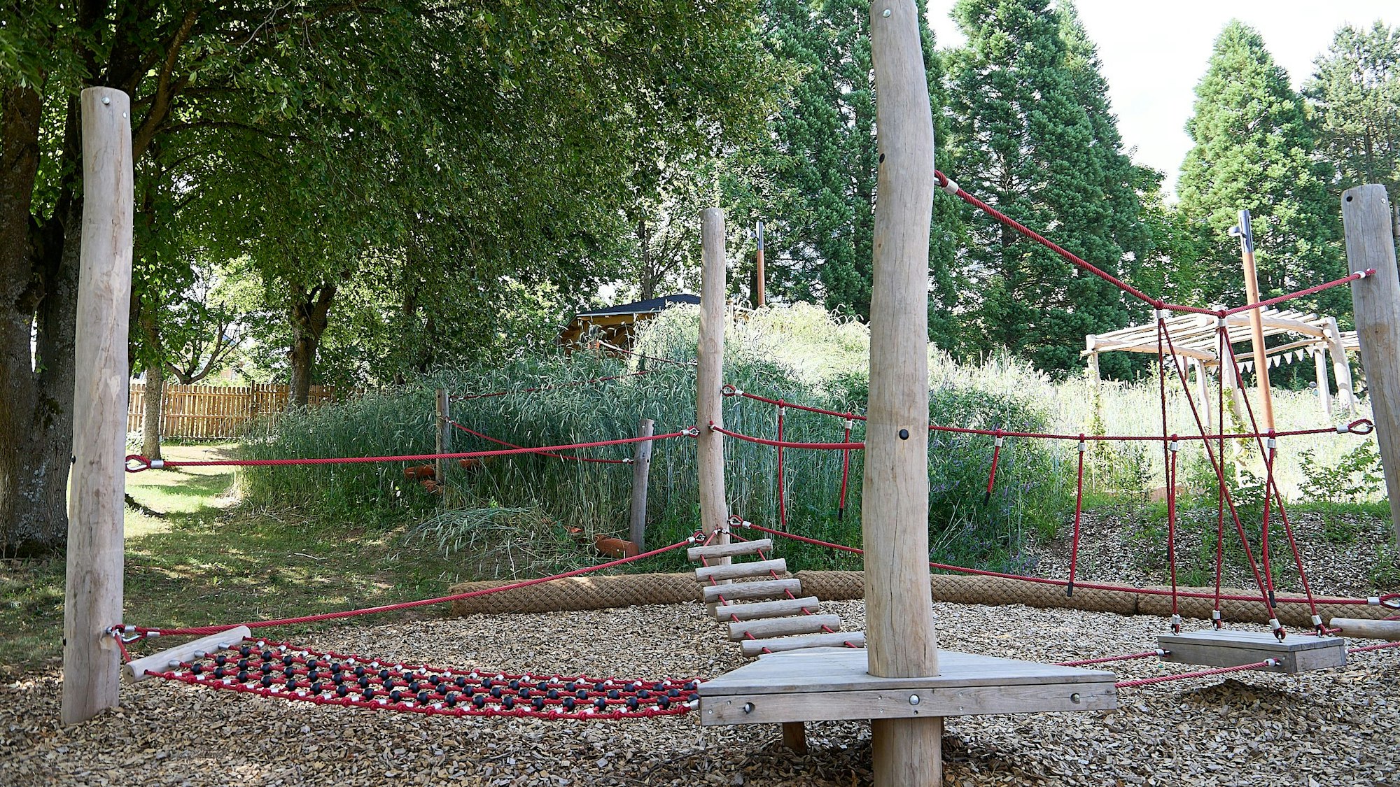 Das Bild zeigt ein Kletter/Spielgerät in einer grünen Umgebung.