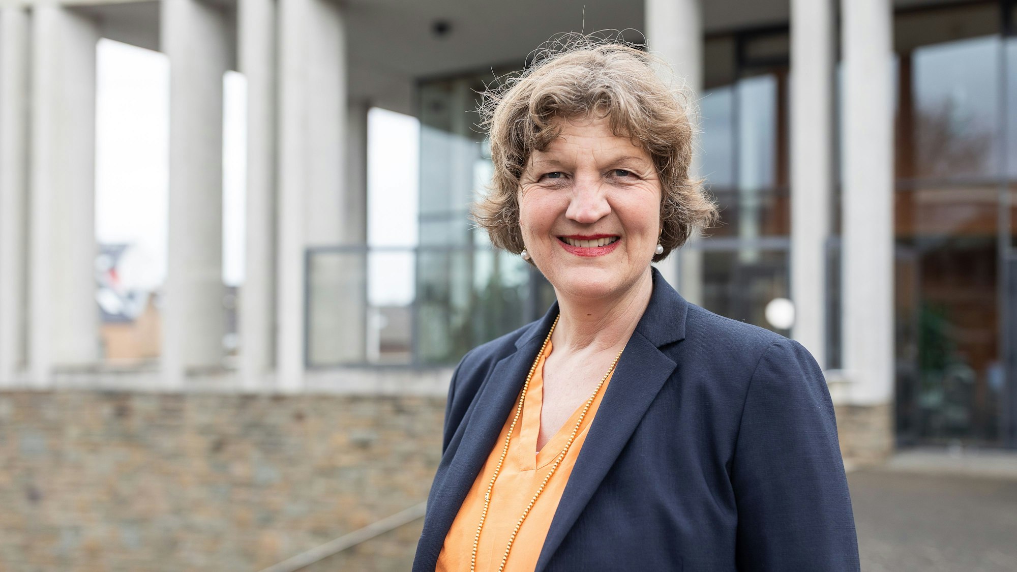 Eine Frau vor einem Gebäude mit weißen Säulen.