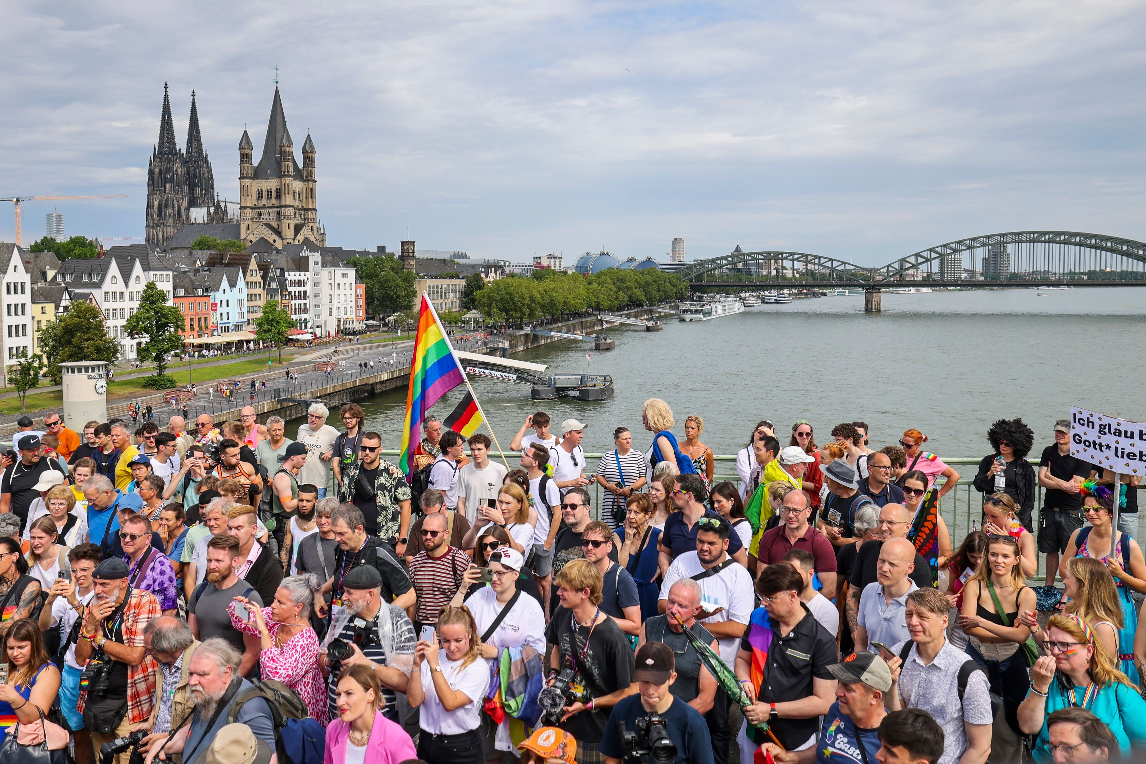 Eine Regenbogenflagge bei den Zuschauern beim CSD in Köln.