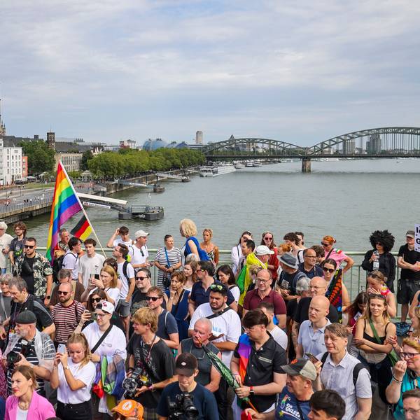 Eine Regenbogenflagge bei den Zuschauern beim CSD in Köln.