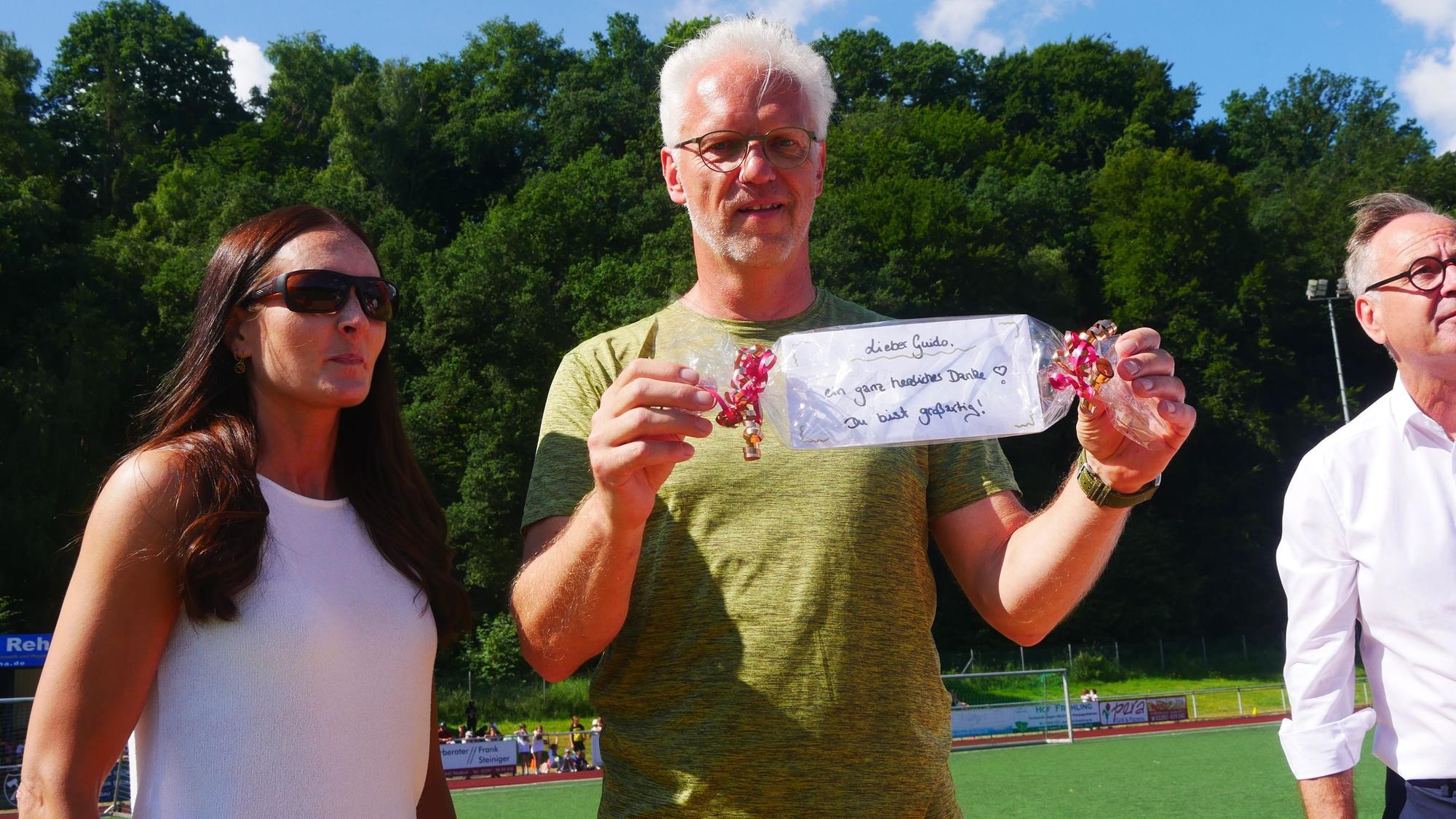Nicola Wojtzyk von der Elternschaft der Förderschule Rossel überreicht Organisator Guido Barz einen Gutschein zum Dank.