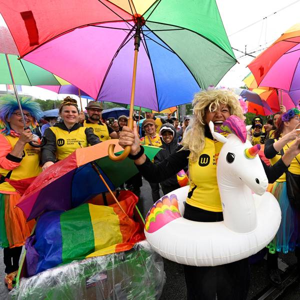 Teilnehmer des Christopher-Street-Day (CSD) Umzugs mit bunten Outfits zelebrieren ihren Protest in den Straßen der Stadt.
