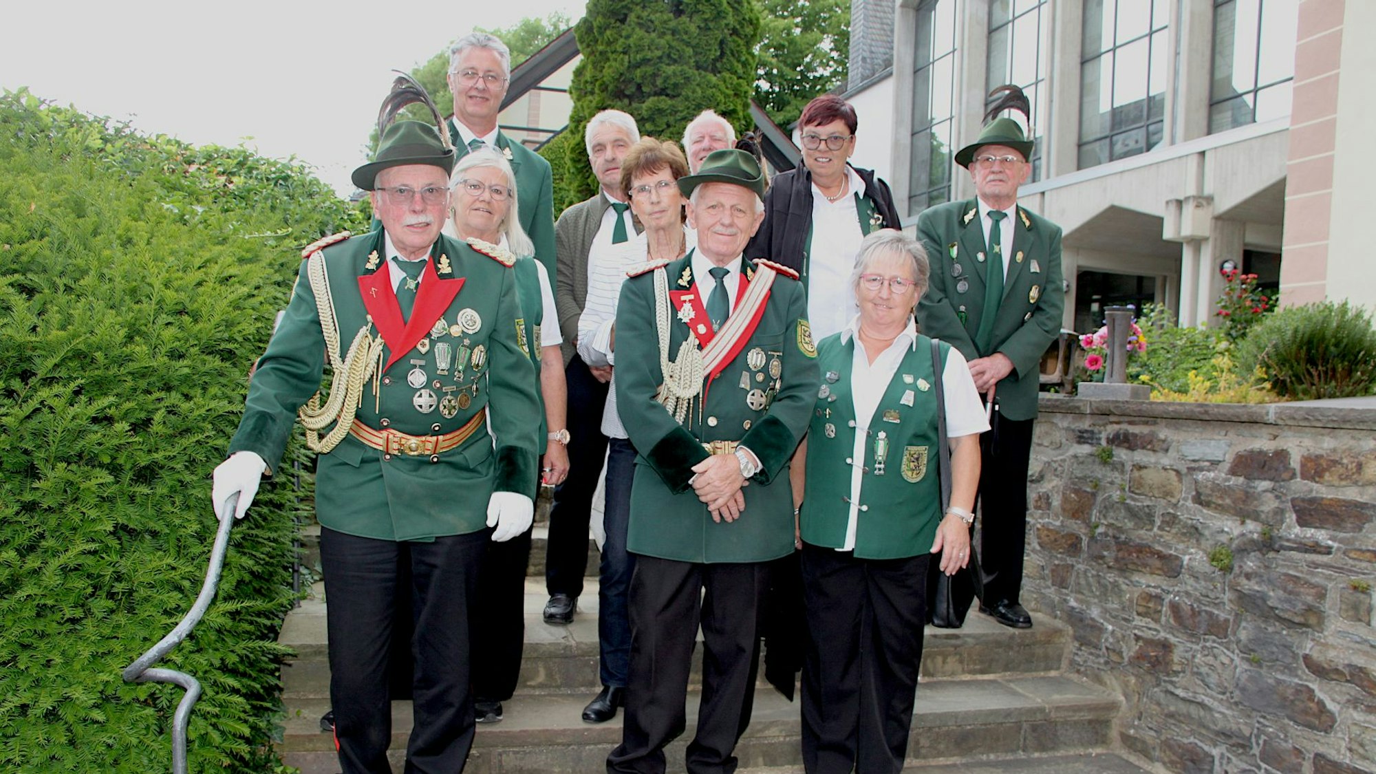 Eine Gruppe in Schützenuniform steht auf einer Treppe.
