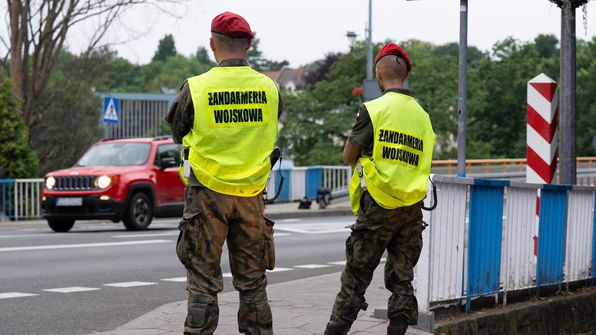 Das Bild zeigt polnische Grenzschützer auf der polnischen Seite hinter der Stadtbrücke von Görlitz, die den Verkehr beobachten. Foto: Sebastian Kahnert/dpa