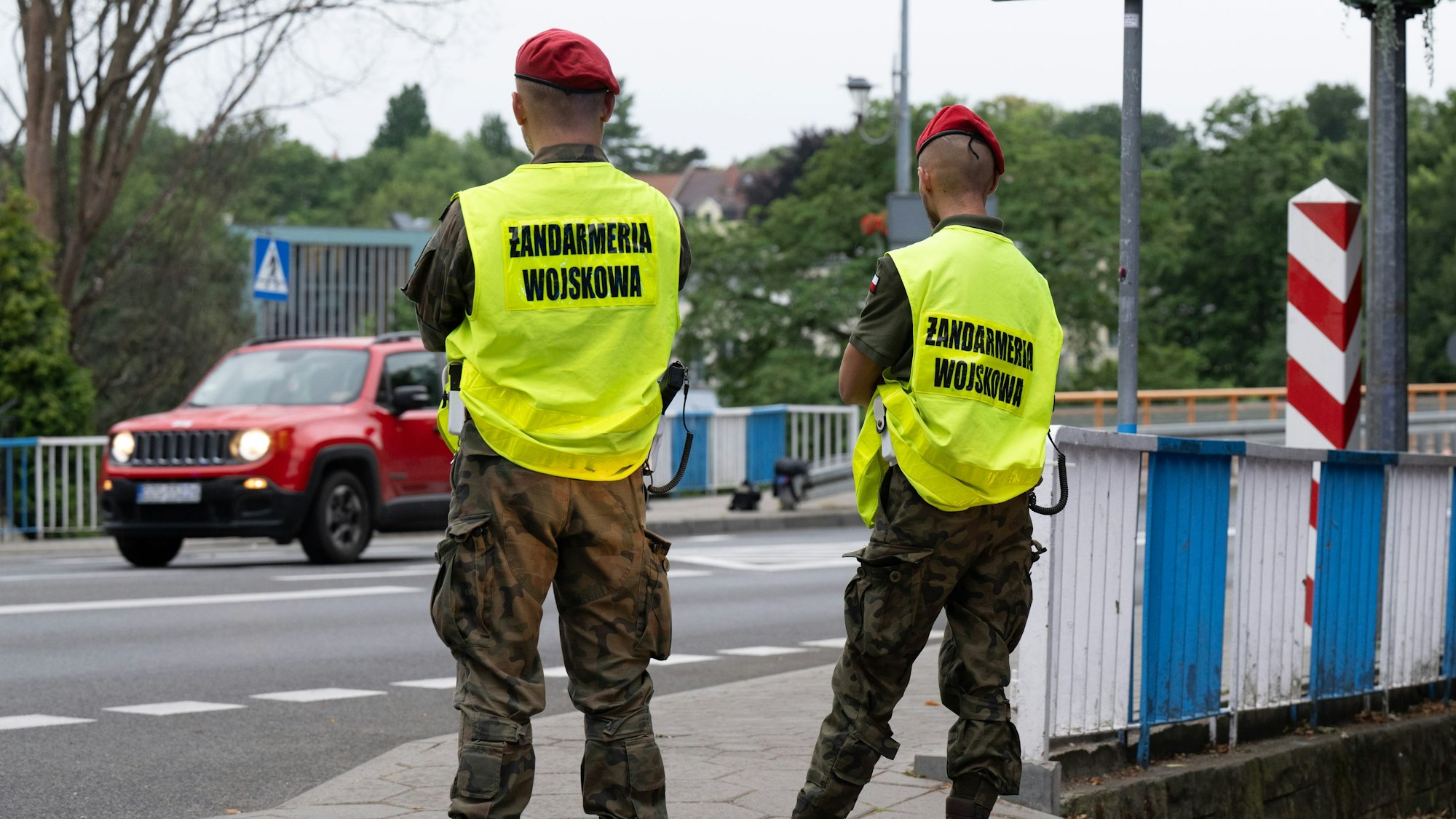 Das Bild zeigt polnische Grenzschützer auf der polnischen Seite hinter der Stadtbrücke von Görlitz, die den Verkehr beobachten. Foto: Sebastian Kahnert/dpa