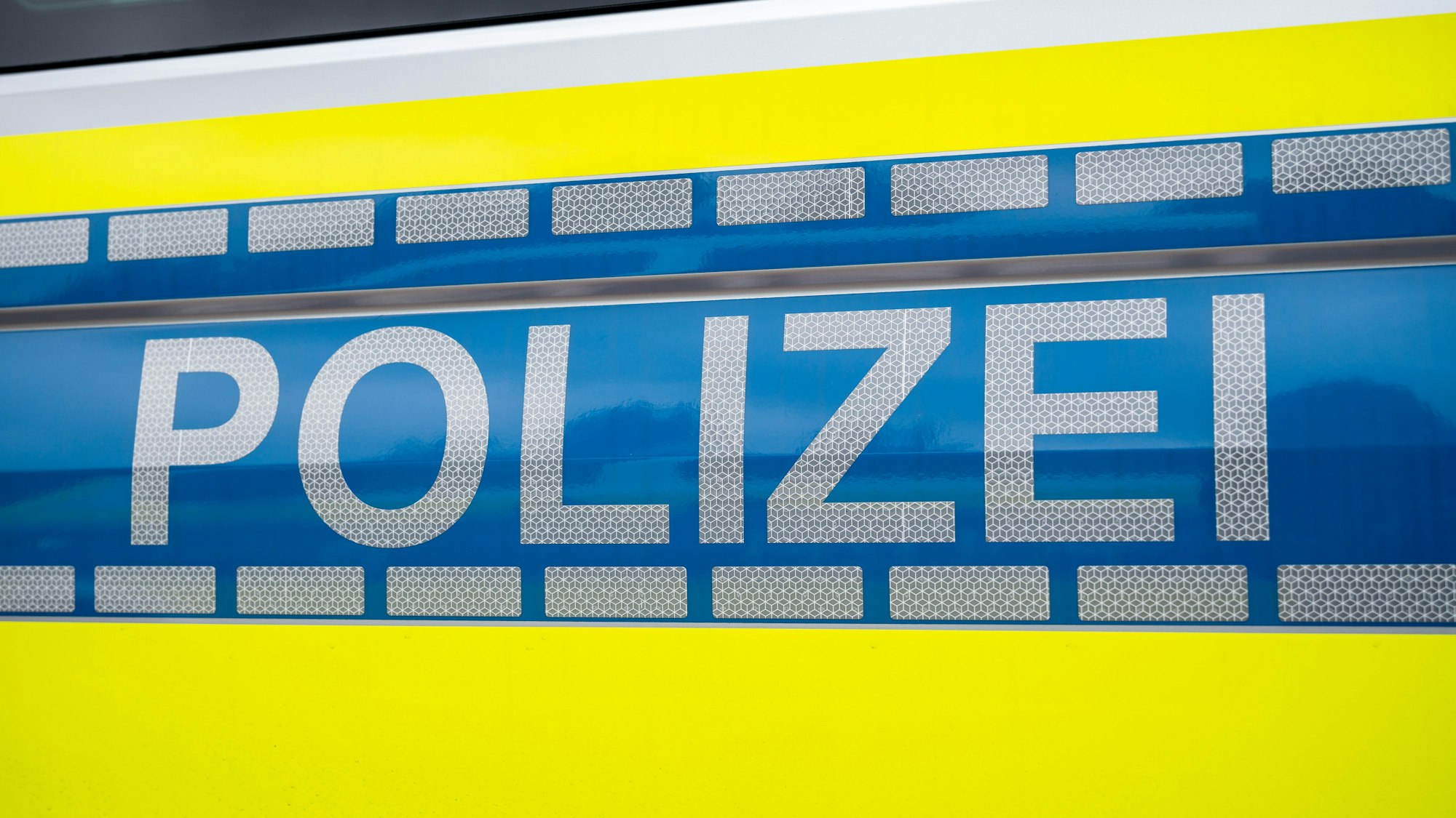 Der Schriftzug "Polizei" steht auf einem Einsatzfahrzeug.