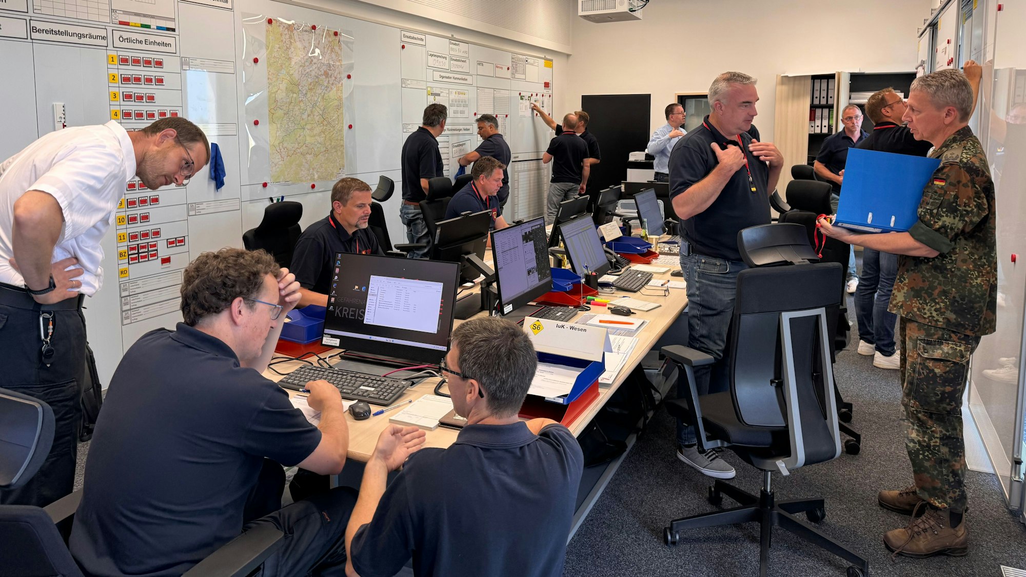 Menschen arbeiten und besprechen sich im Lagezentrum des Kreises Euskirchen.