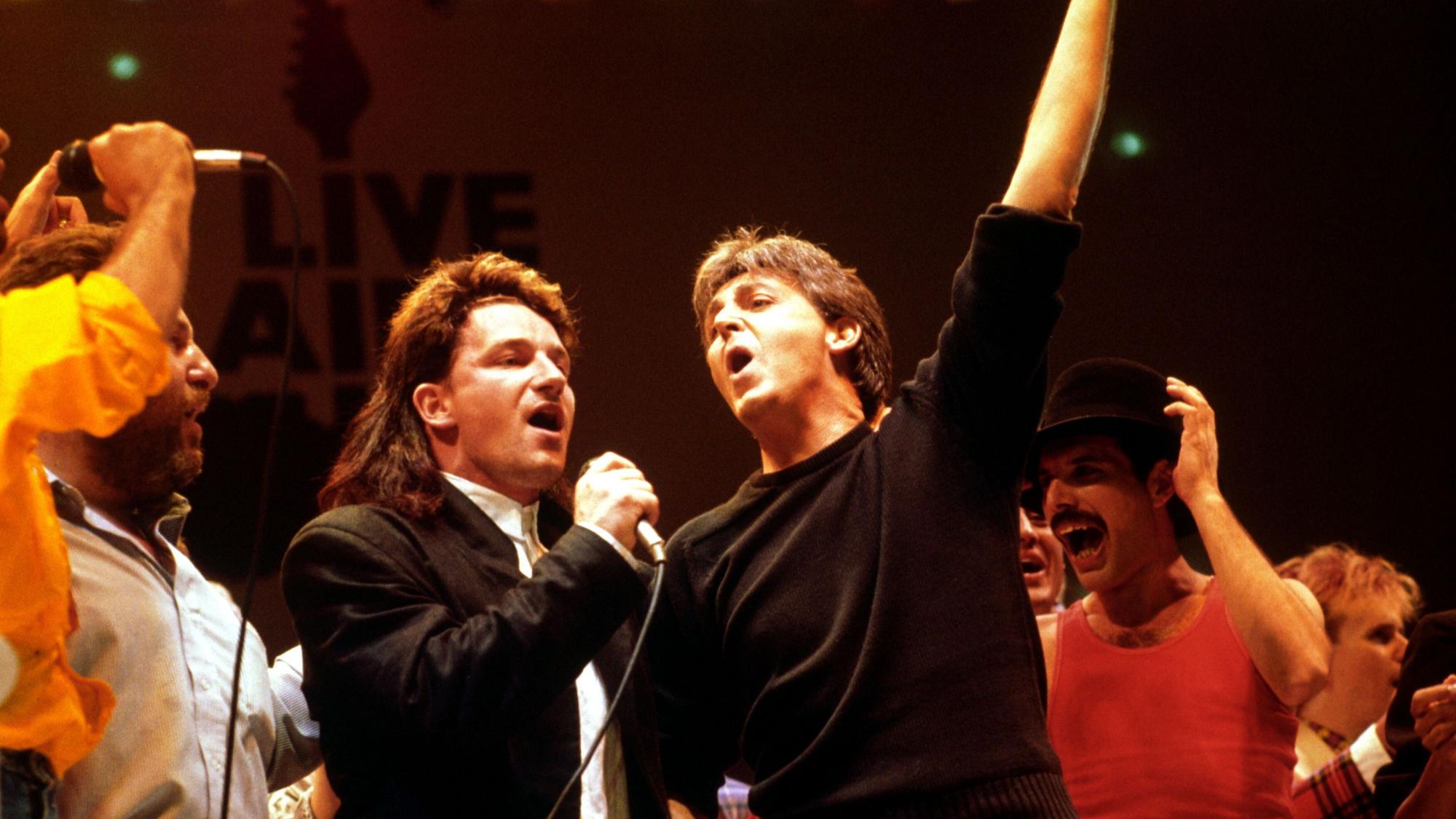 Bono von der irischen Rockband U2 (l-r), Paul McCartney und Freddy Mercury von der britischen Rockband Queen, treten am 13.07.1985 in London (Großbritannien) im Wembley Stadion bei dem Live Aid Konzert auf.