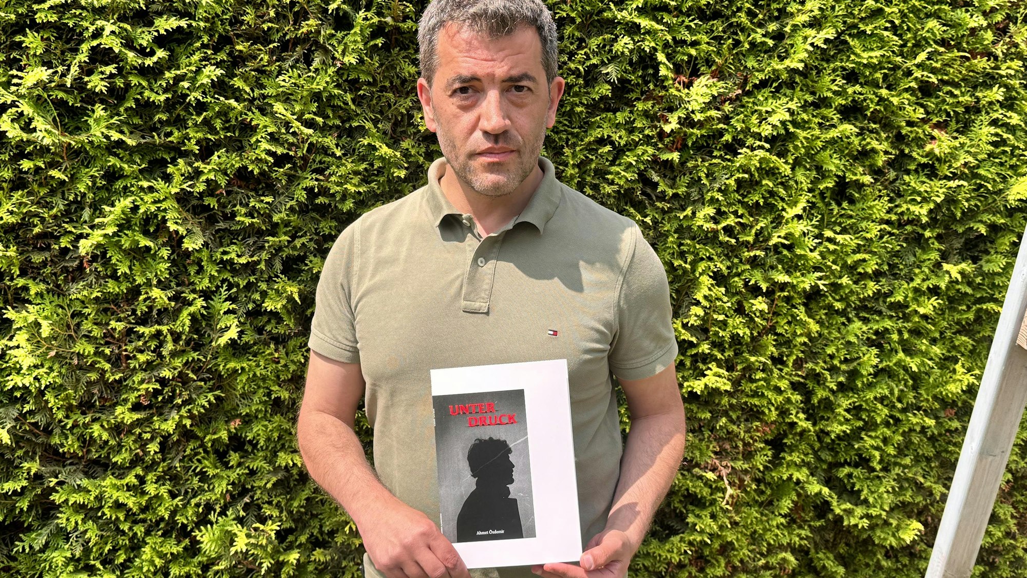 Das Foto zeigt Ahmet Özdemir mit seinem neuen Buch in Sindorf.