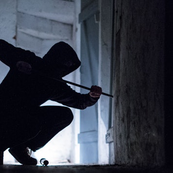 ILLUSTRATION - Ein "Einbrecher" hebelt mit einem Brecheisen eine Tür im Keller eines Wohnhauses auf (gestellte Szene).