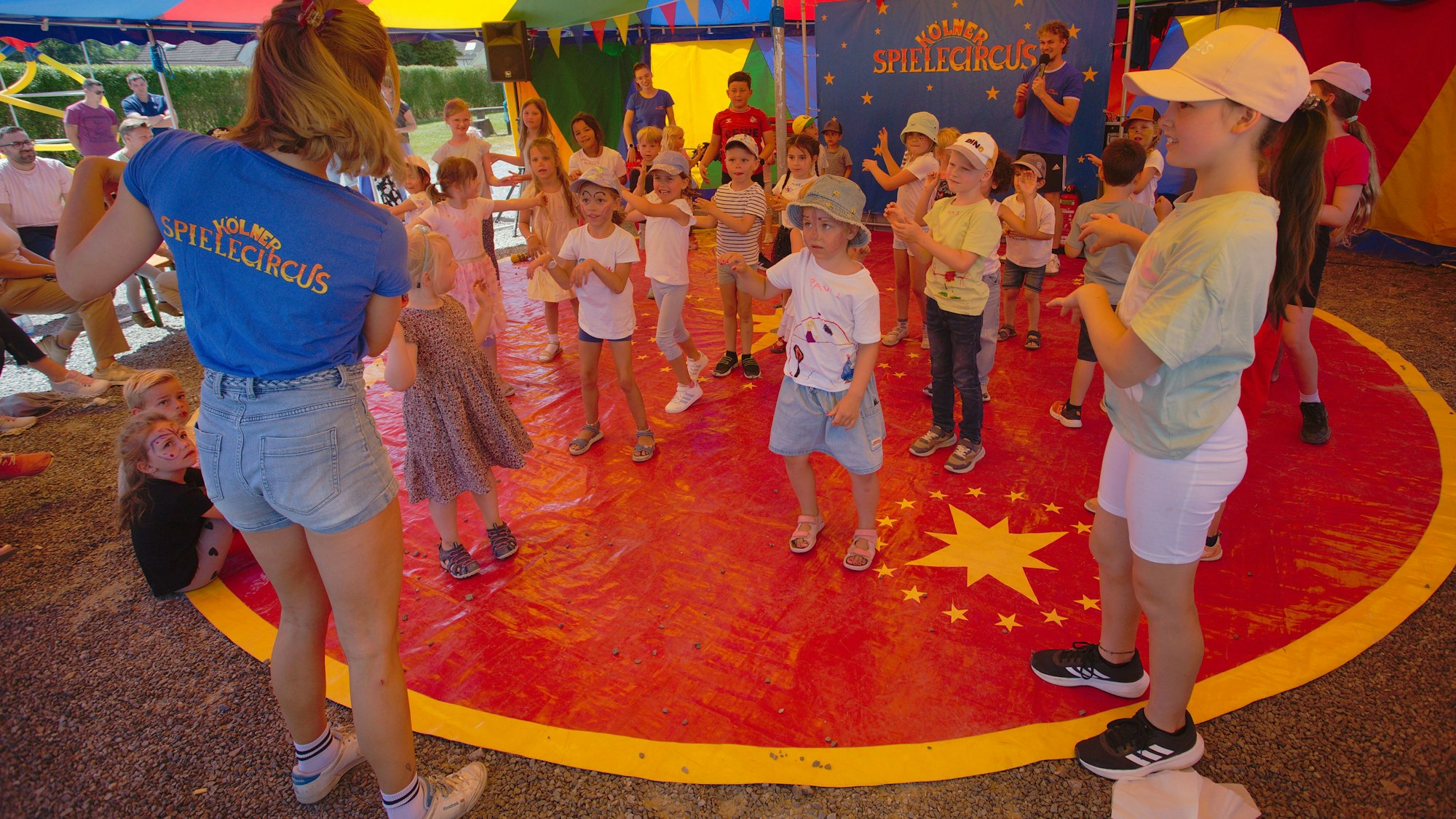 Das Foto zeigt Kinder in der Zirkusmanege.