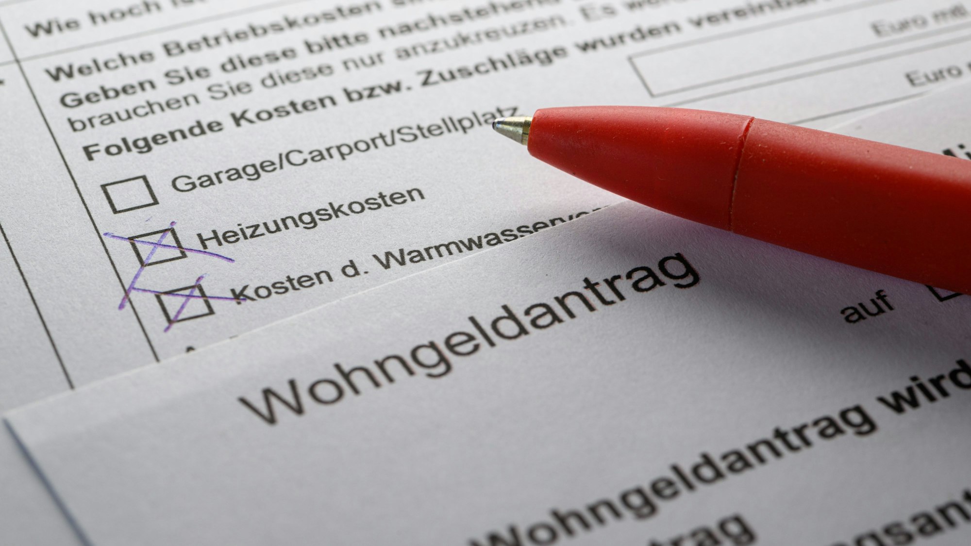Das Symbolbild zeigt einen Antrag auf Wohngeld und einen roten Kugelschreiber.
