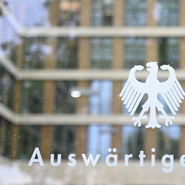 ARCHIV - 27.05.2025, Berlin: Der Bundesadler und der Schriftzug «Auswärtiges Amt» sind an einer Glasscheibe an einem Eingang zum Auswärtigen Amt zu sehen. (zu dpa: «Deutsches Botschaftspersonal aus Teheran ins Ausland verlegt») Foto: Katharina Kausche/dpa +++ dpa-Bildfunk +++