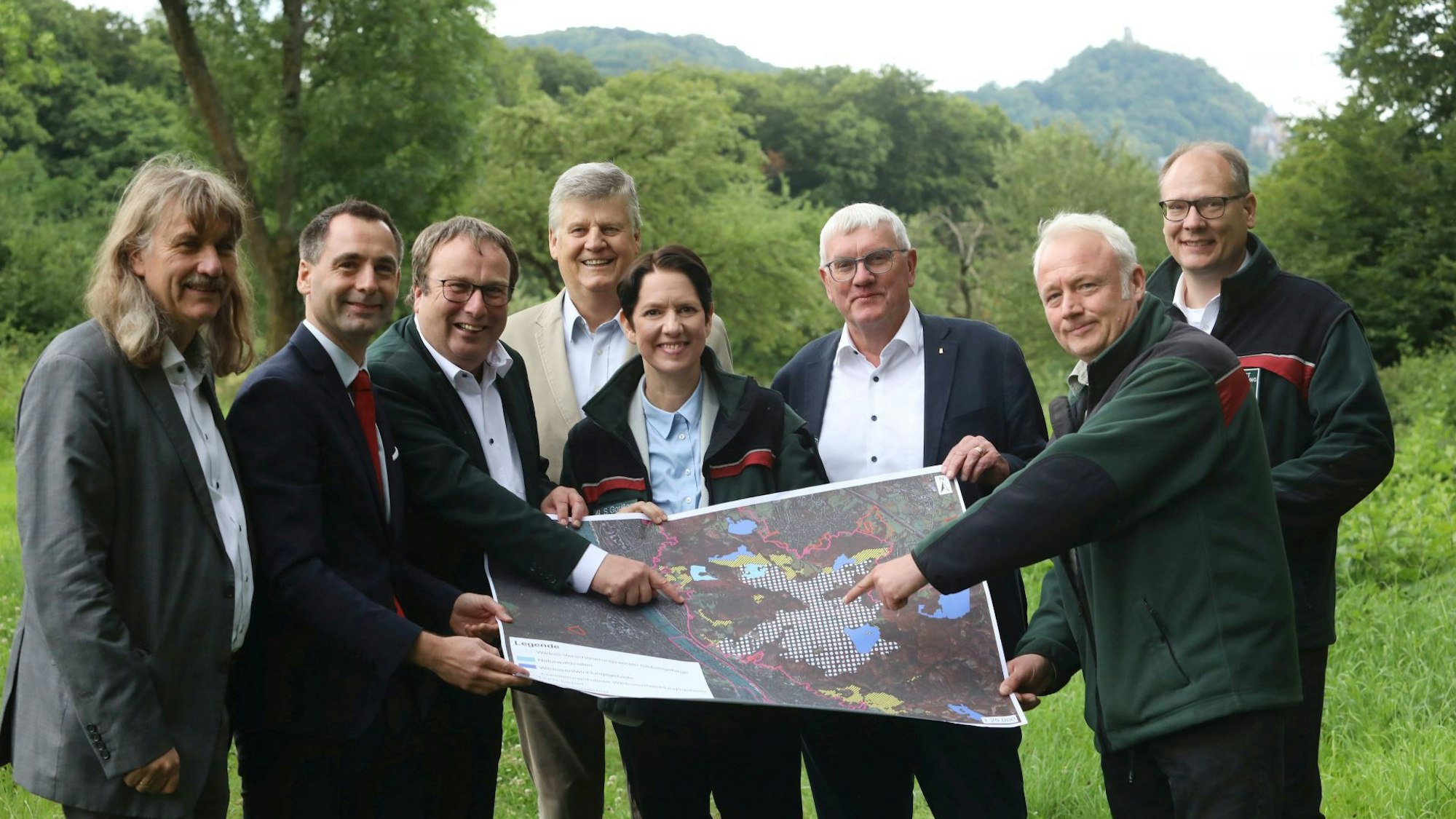Eine Gruppe von sieben Männer und einer Frau mit einer Karte der Siebengebirgsregion.