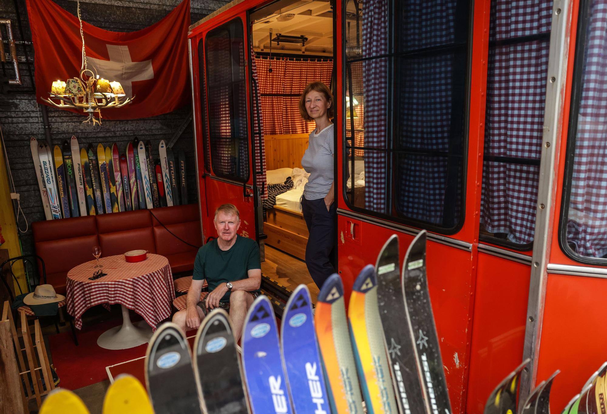 Paul Starrach (l) und Renate Rothenbächer aus Gießen stehen im Basecamp vor einer ehemaligen Gondel der Schweizer Bergbahnen.