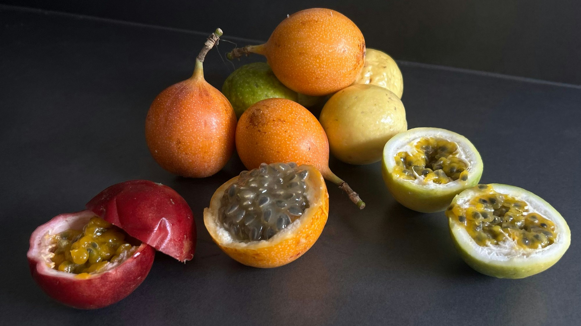 Eine rote und gelbe Passionsfrucht und eine Granadilla geöffnet.