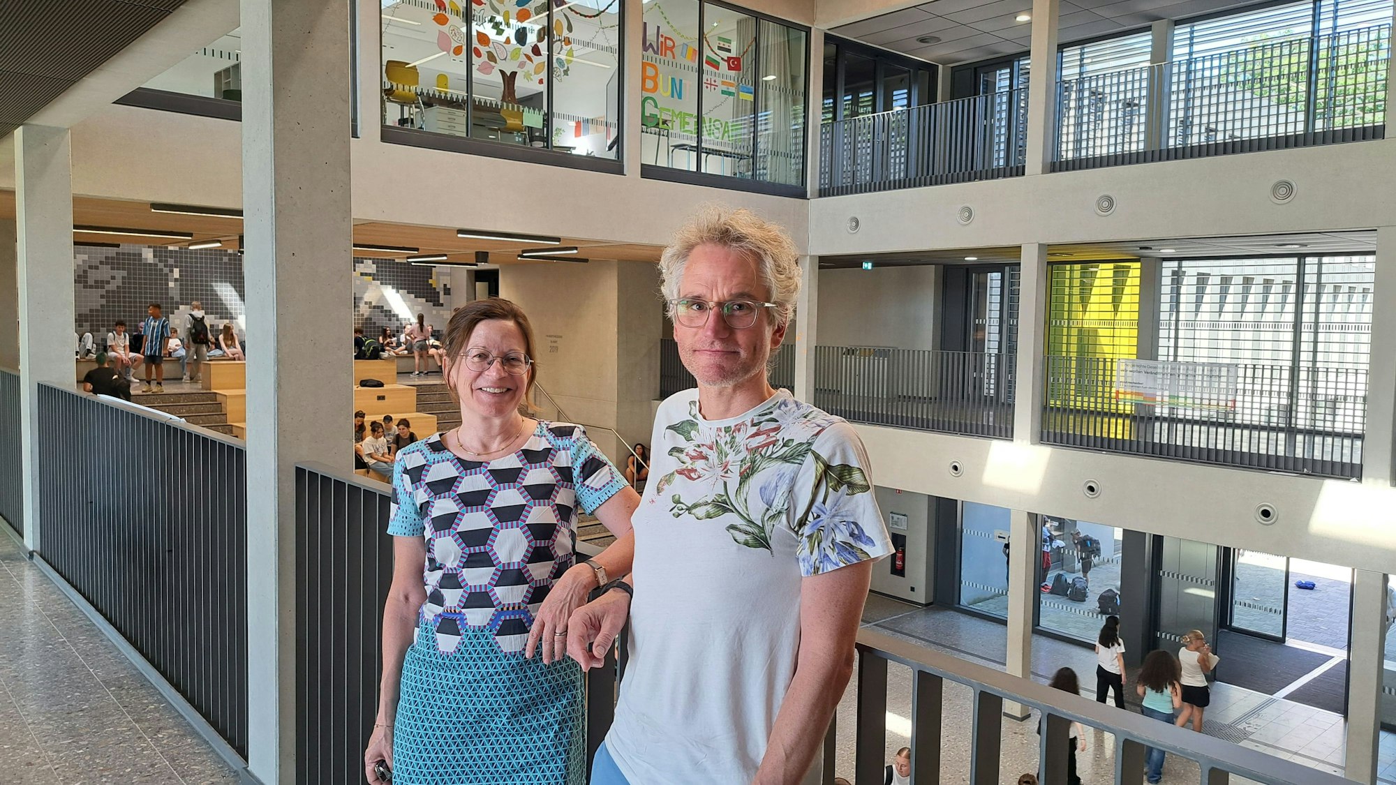 Eine Frau und ein Mann stehen im offenen Gebäudetrakt der Willy-Brandt-Gesamtschule
