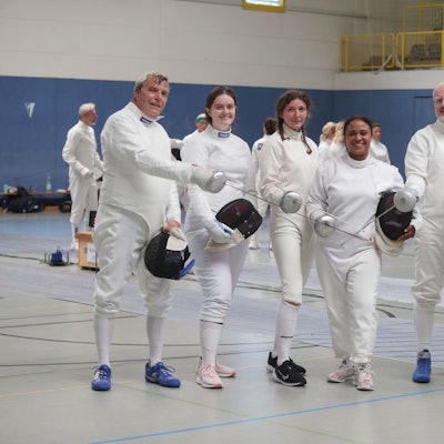 Sechs Fechterinnen und Fechter posieren mit ihren Degen für ein Foto.