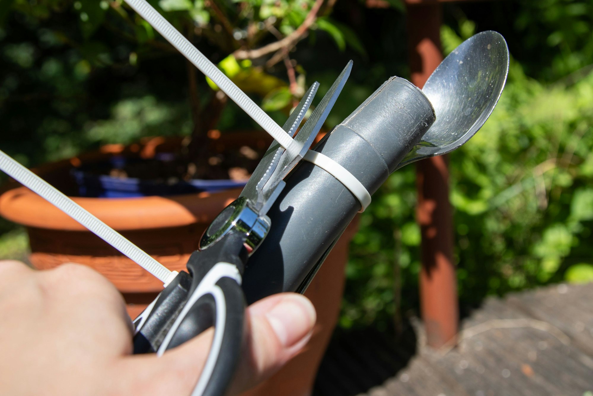 Schritt 2: Die überstehenden Enden des Kabelbinders mit der Schere abschneiden.