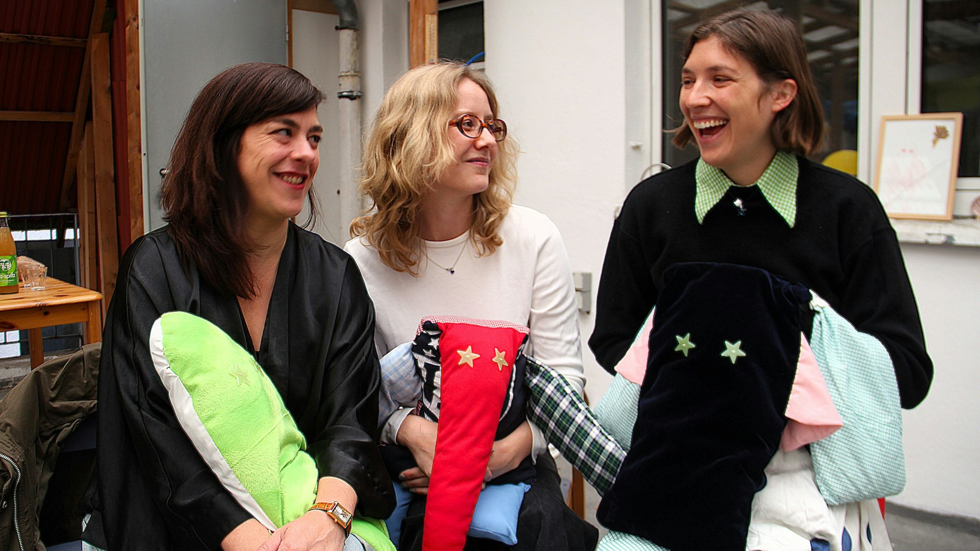 Drei Frauen stehen nebeneinander und Kuscheltiere in den Händen