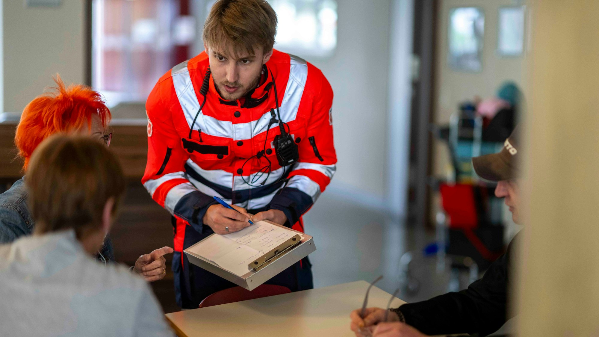 Ein Malteser-Mitarbeiter im Gespräch mit Evakuierten.