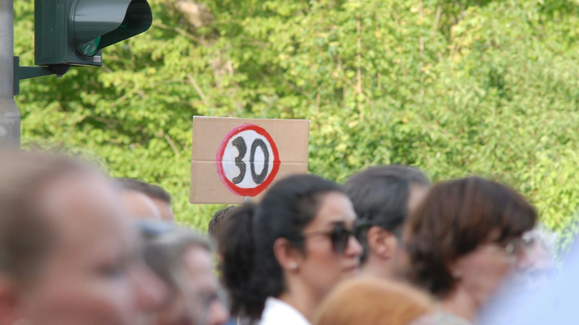 Mehrere Hundert Menschen nahmen im Sommer 2025 in Hürth an der Mahnwache für die beiden Menschen teil, die bei dem Verkehrsunfall ums Leben gekommen waren. Auf einem Schild war auch die Forderung nach Tempo 30 zu sehen.