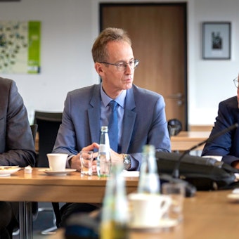 Bundesverkehrsminister Patrick Schnieder, MdB Detlef Seif und Mechernichs Bürgermeister Dr. Hans-Peter Schick (v.l.), alle CDU, sitzen nebeneinander an einem Tisch im Ratssaal in Mechernich.