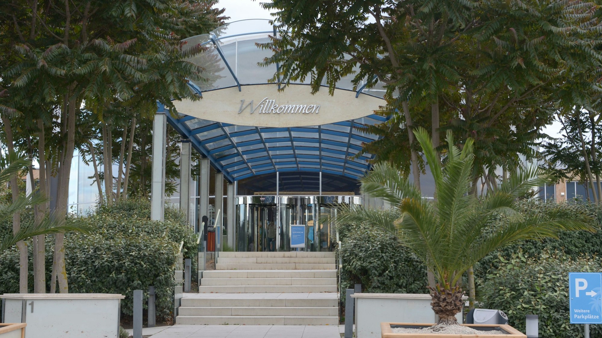 Das Bild zeigt den Eingang der Therme mit dem Schriftzug „Willkommen“.