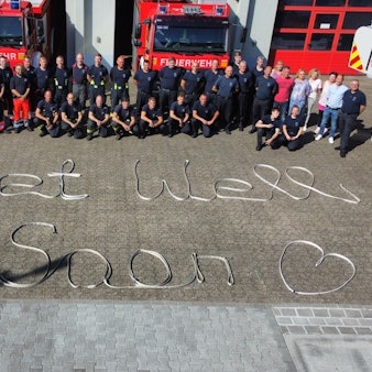 Die Schicht des bei einem Einsatz als Rettungssanitäter an der Stadthalle Troisdorf angegriffenen Feuerwehrmann legte aus Schläuchen ein ‚Get Well Soon‘ an der Feuerwache in Sieglar.