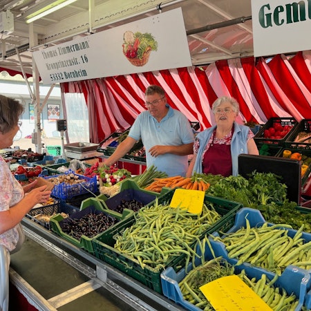 Zu sehen ist der Gemüsestand von Thomas Zimmermann, eine weitere Frau bedient eine Kundin.