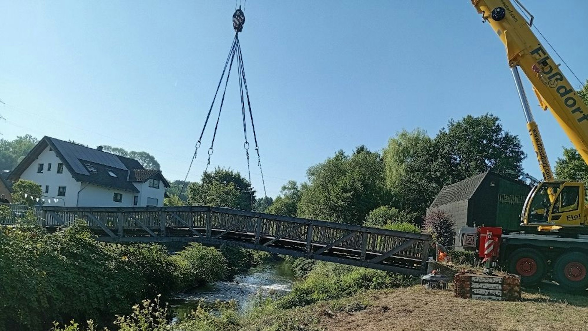 Ein Autokran hebt die Brücke an.