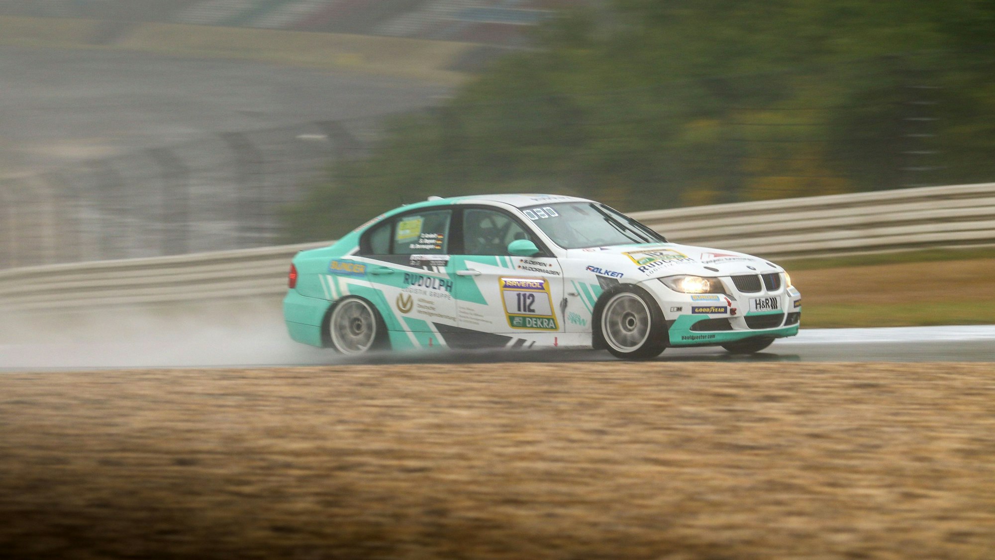 Ein BMW 325i Rennauto fährt über eine Strecke.