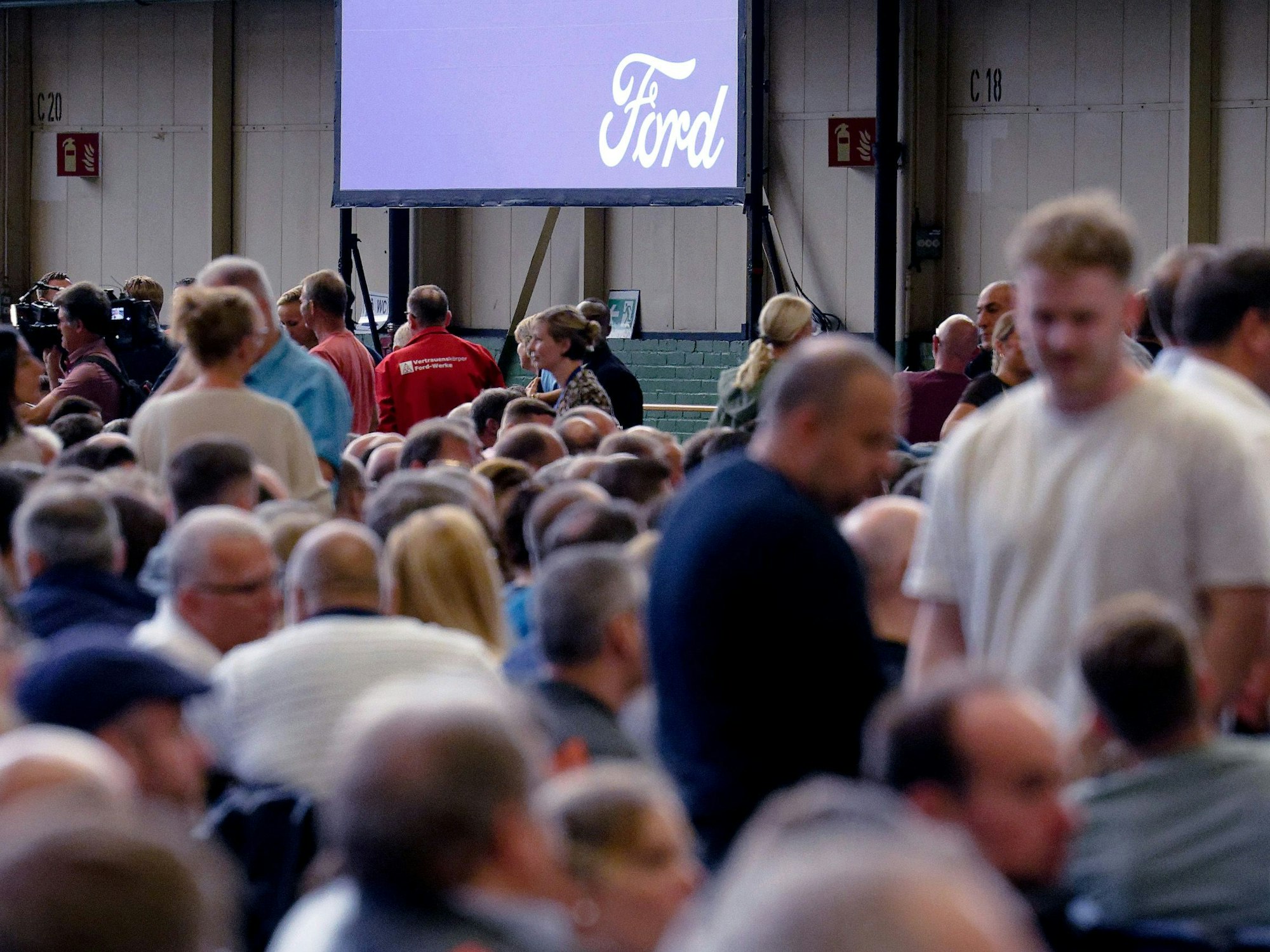 Mitarbeiter warten auf den Beginn einer Mitarbeiterversammlung in den Kölner Ford-Werken.
