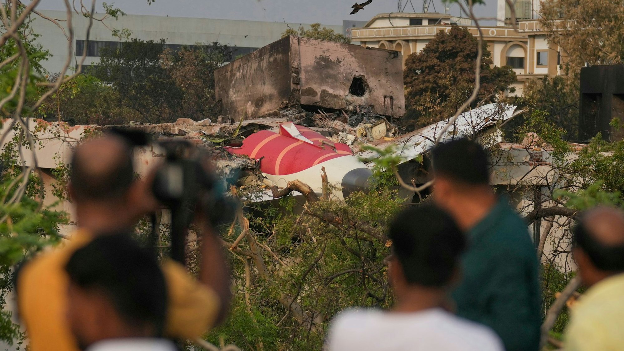Menschen betrachten die Wrackteile des am Donnerstag (12.06.2025) abgestürzten Flugzeugs von Air India. (Foto Archiv)
