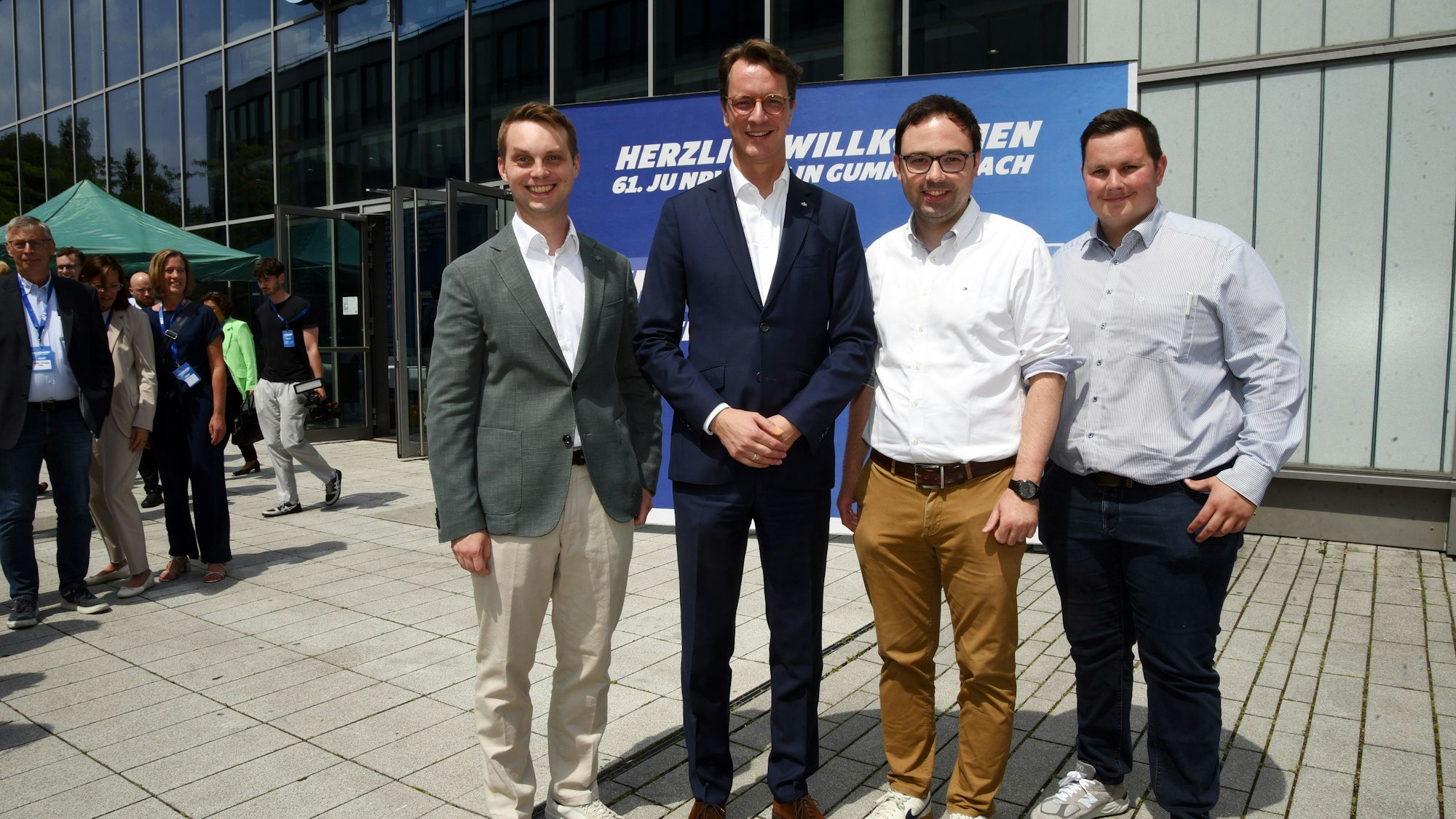 Vier Männer vor einer Veranstaltungshalle.