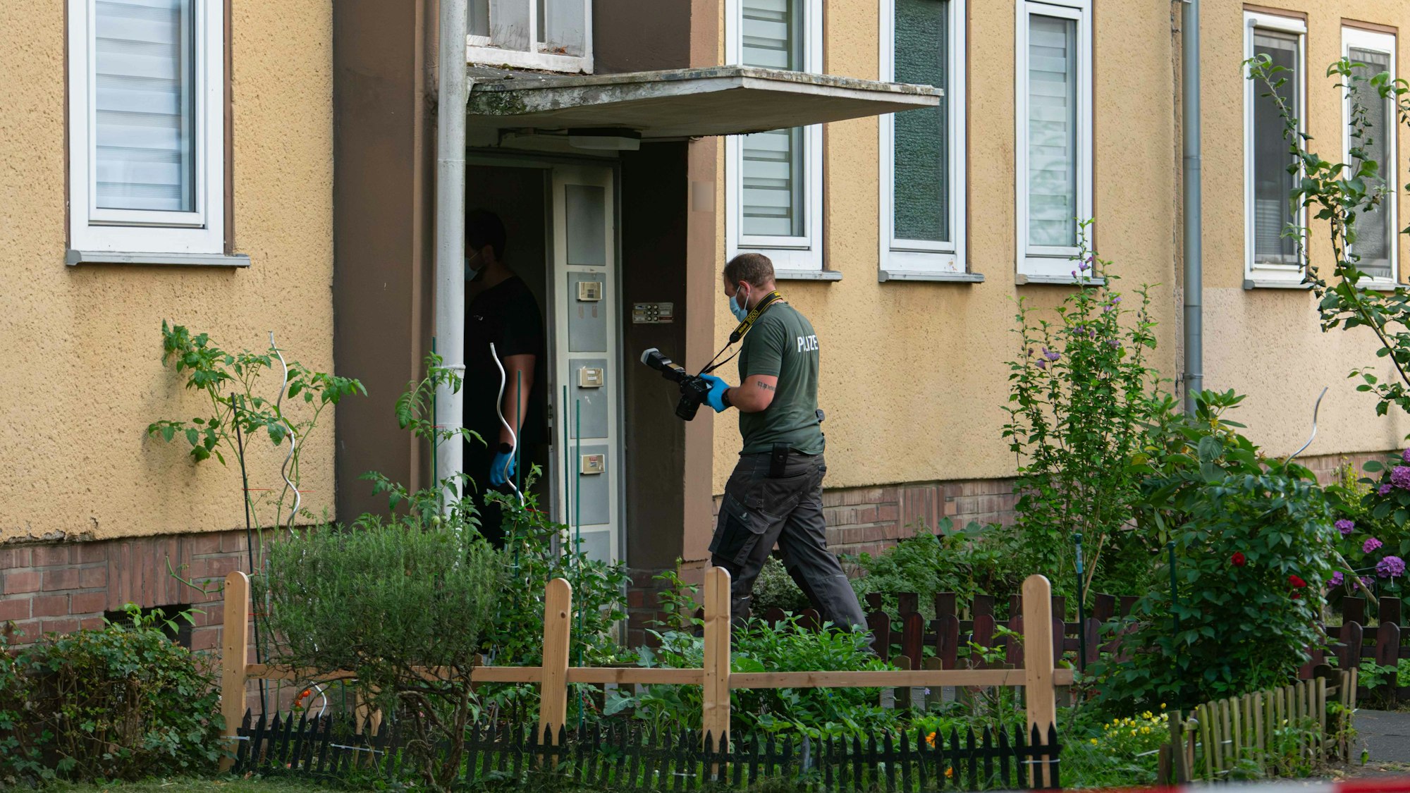 11.07.2025, Nordrhein-Westfalen, Dormagen: Ermittler der Polizei betreten ein Wohnhaus. Die Polizei Dormagen fand am Freitagnachmittag in einer Wohnung eine 37-jährige Tote. Wenig später nahm sie einen 17-Jährigen fest - es ist der Sohn der Frau. Eine Mordkommission ermittelt. Foto: Vincent Kempf/dpa - ACHTUNG: Hausnummer gepixelt +++ dpa-Bildfunk +++